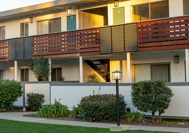 Apartments for Rent Hayward CA - Jackson Flats - Apartment building surrounded by a well-maintained lawn and trees