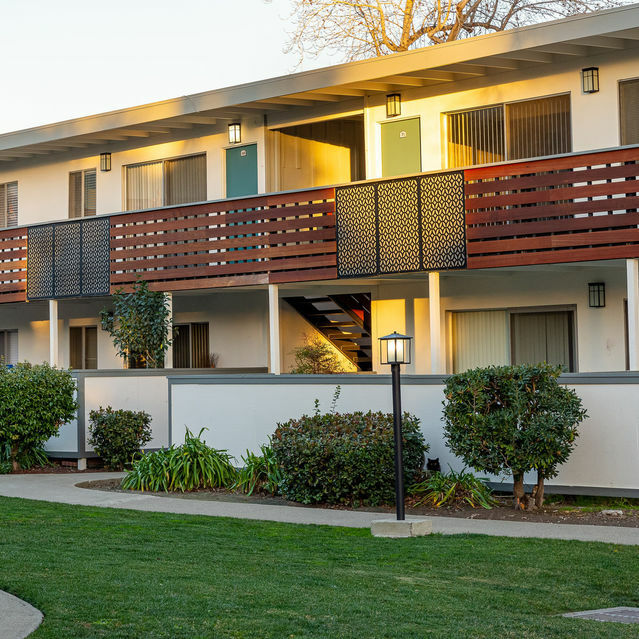 Apartments for Rent Hayward CA - Jackson Flats - Apartment building surrounded by a well-maintained lawn and trees